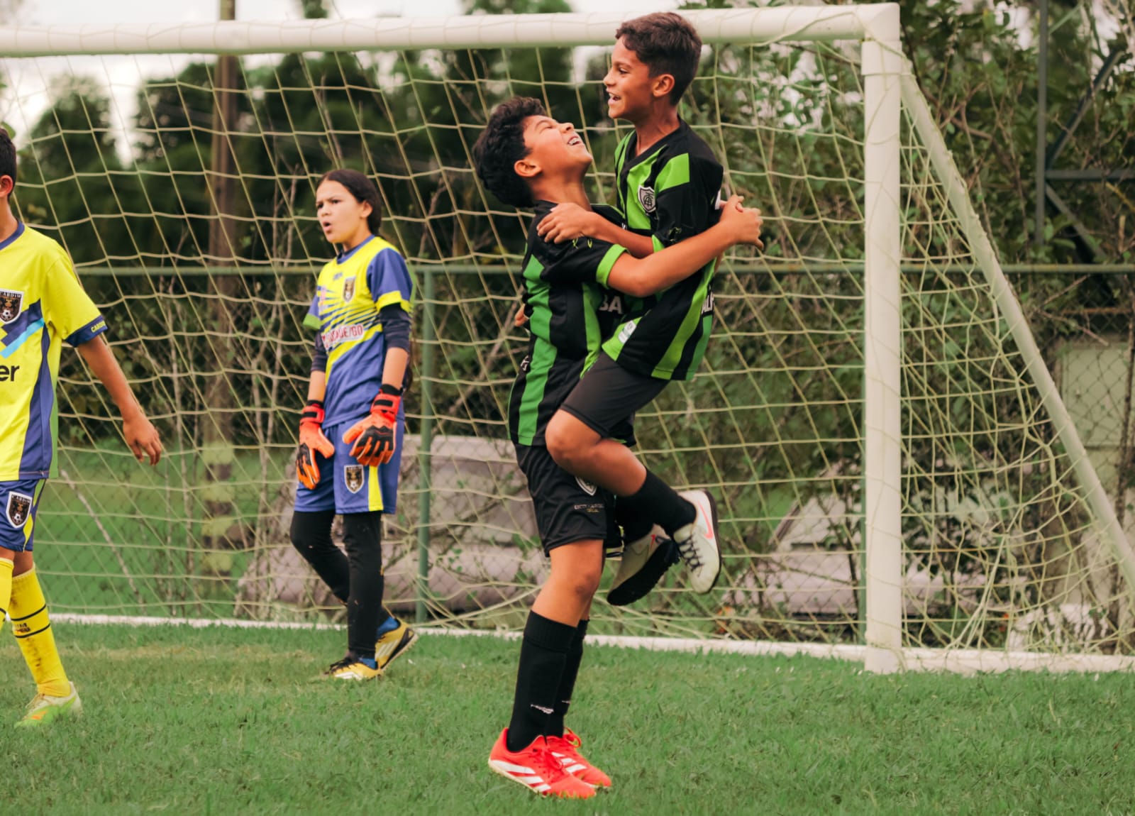 Dois alunos pequenos comemorando juntos durante a partida